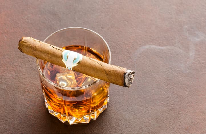 A cigar and a glass of whiskey